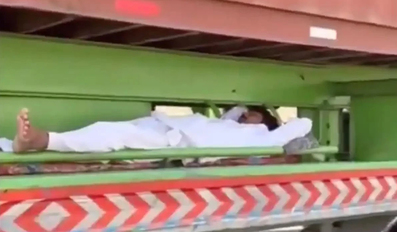 A man sleeping underneath a fast-moving truck